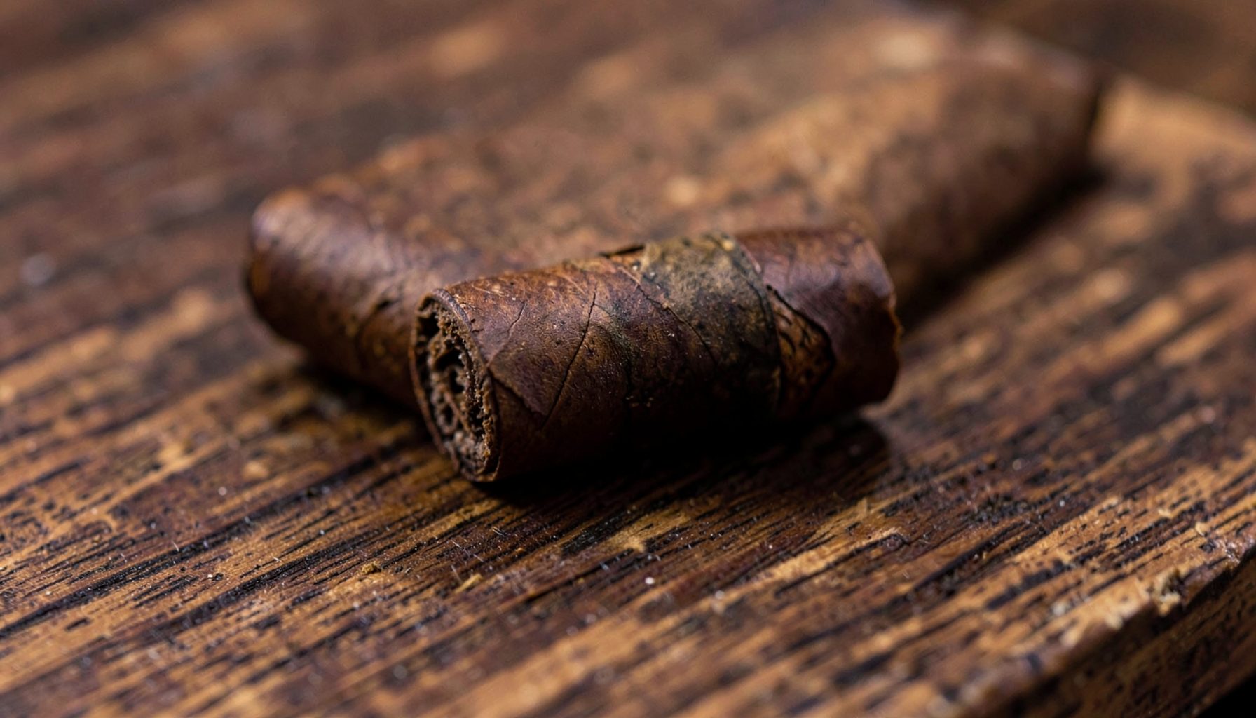 A close-up of a hand-rolled cigar with a dark wrapper resting on a cedar plank, rich brown and earthy tones